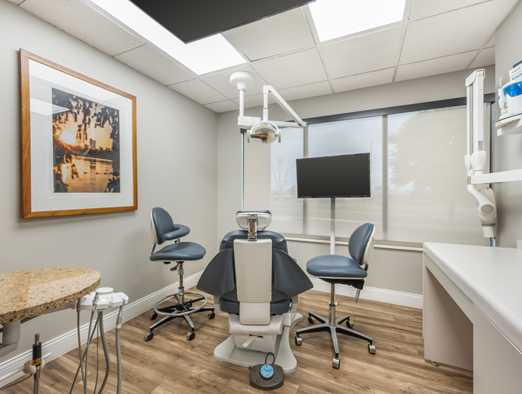 Golden Hill Family Dentistry | Dental professional wearing gloves performing a procedure while colleagues observe.